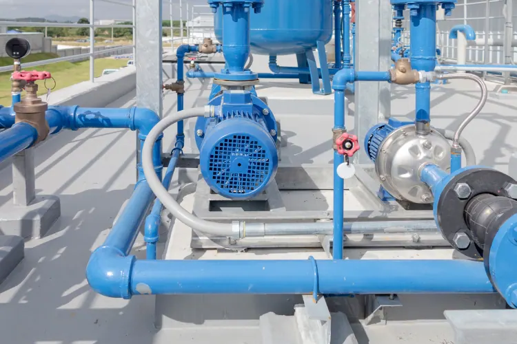 Grupo de bombas centrífugas con tuberías azules en una planta de tratamiento